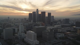 DCLA_035 - 5K stock footage aerial video approach Downtown Los Angeles skyline with setting sun behind clouds, California