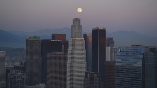 DCLA_071 - 5K aerial stock footage tilt from rush hour traffic on I-110 to reveal moon over Downtown Los Angeles at twilight, California