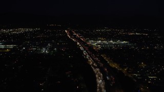 DCLA_098 - 5K aerial stock footage tilt from highway 118 to reveal and approach shopping center at night in Pacoima, California