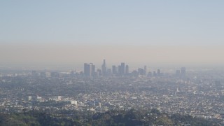 DCLA_107 - 5K aerial stock footage fly over a green mountain to reveal Downtown Los Angeles skyline, California