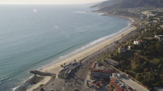 DCLA_136 - 5K stock footage aerial video tilt from Highway 1 to reveal beach in Pacific Palisades, California