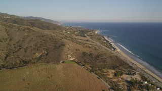 DCLA_166 - 5K aerial stock footage fly over mountains to reveal and approach Highway 1 on the coast in Malibu, California