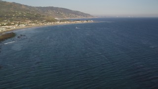 DCLA_170 - 5K aerial stock footage fly over seagulls over the ocean and tilt to reveal Malibu, California