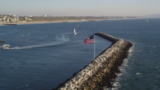 DCLA_186 - 5K aerial stock footage flyby American flag on breakwater near sailboats and sport boats in Marina Del Rey, California
