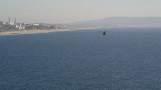 DCLA_188 - 5K aerial stock footage track military helicopter to reveal the coastline in El Segundo, California
