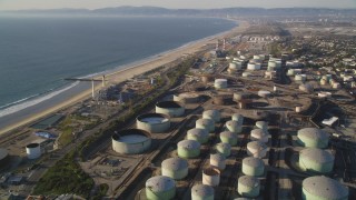 DCLA_195 - 5K stock footage aerial video fly over oil tanks at refinery to approach beach in El Segundo, California