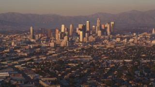 DCLA_206 - 5K aerial stock footage tilt from urban neighborhood to reveal Downtown Los Angeles skyline at sunset, California