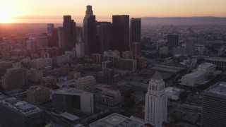 DCLA_242 - 5K stock footage video orbit and tilt from city hall to reveal skyline of Downtown Los Angeles at sunset, California