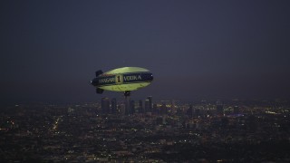 DCLA_279 - 5K aerial stock footage of flying by an advertising blimp and reveal Downtown Los Angeles skyline at twilight, California