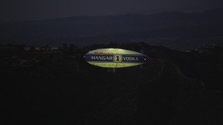 DCLA_280 - 5K aerial stock footage of tracking a blimp flying by Hollywood Hills at twilight, California