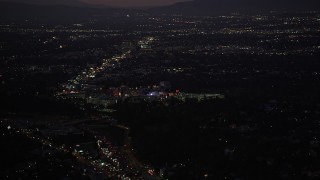 DCLA_284 - 5K aerial stock footage tilt from Highway 101 traffic to reveal Universal City at night, California