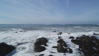 DCSF02_017 - 5K stock footage aerial video Fly low over Pacific Ocean waves and rocks, pan to reveal coastal cliffs, Avila Beach, California
