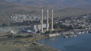 DCSF03_001 - 5K stock footage aerial video Flying by Dynegy Morro Bay power plant, eclipsed by Morro Rock, Morro Bay, California