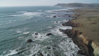 DCSF03_004 - 5K stock footage aerial video Fly over coastal cliffs and empty beach, and tilt up to follow the coast, Estero Bay, California