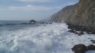 DCSF03_028 - 5K stock footage aerial video Flying low over crashing waves, rocks, coastal cliffs, San Simeon, California
