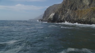 DCSF03_030 - 5K aerial stock footage Fly low over ocean waves, rocks, by coastal cliffs, San Simeon, California