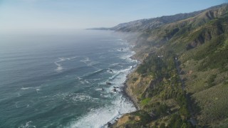 DCSF03_047 - 5K stock footage aerial video Fly over cliffs on the California coast with ocean waves rolling in, Big Sur, California