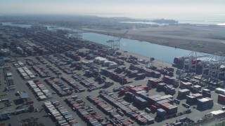 DCSF05_076 - 5K aerial stock footage Flyby cargo containers to ships docked under cranes, Port of Oakland, Oakland, California