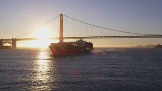 DCSF07_037 - 5K aerial stock footage Low altitude flyby of a cargo ship near the Golden Gate Bridge, San Francisco, California, sunset