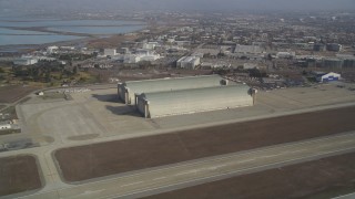 DCSF08_021 - Aerial stock footage of 5K Aerial Video Tilt from a parked jet to reveal and approach Hangar Two and Three, Moffett Field, Mountain View, California