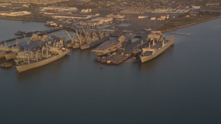 DCSF10_001 - Aerial stock footage of 5K Aerial Video Flyby base and reveal USS Hornet and ships at Naval Air Station Alameda, California, sunset