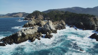 DCSF11_015 - Aerial stock footage of 5K Aerial Video Passing ocean waves crashing into coastal rock formations, Carmel, California