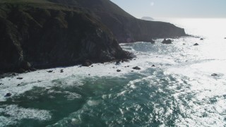 DCSF11_022 - Aerial stock footage of 5K Aerial Video Tilt from ocean waves to reveal tall coastal cliffs, Big Sur, California