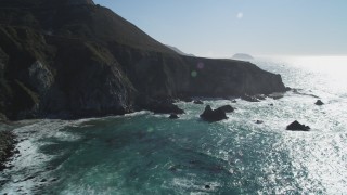 DCSF11_023 - Aerial stock footage of 5K Aerial Video Flying by waves crashing into the base of coastal cliffs, Big Sur, California