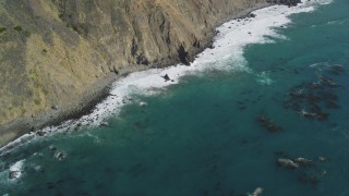 DCSF11_033 - Aerial stock footage of 5K Aerial Video Bird's eye view of kelp near waves rolling toward coastal cliffs, Big Sur, California