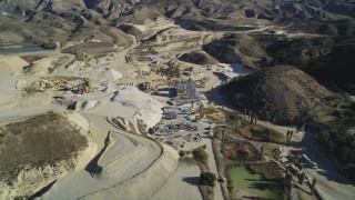 DFKSF01_001 - 5K aerial stock footage of orbiting a quarry with industrial equipment, Simi Valley, California