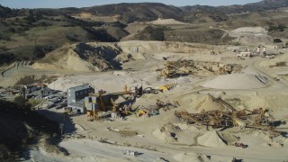 DFKSF01_002 - 5K aerial stock footage of flying by a quarry and industrial equipment, Simi Valley, California