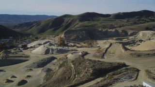 DFKSF01_004 - 5K aerial stock footage of flying by a quarry and industrial equipment, Simi Valley, California