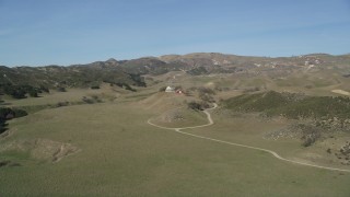 DFKSF01_007 - 5K aerial stock footage of flying over a hill, revealing isolated ranch house and barn, Simi Valley, California