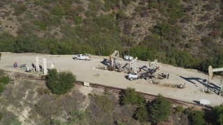 DFKSF01_020 - 5K aerial stock footage of flying away from four oil rigs drilling on a hilltop, Santa Paula, California