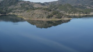 DFKSF01_029 - 5K aerial stock footage of flying over the lake, tilt up to reveal hills on the shore, Lake Casitas, California