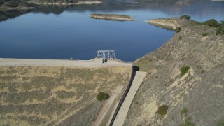 DFKSF01_030 - 5K stock footage aerial video of following an aqueduct uphill, revealing Casitas Dam, Lake Casitas, California