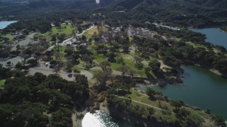 DFKSF01_059 - 5K aerial stock footage of flying by a lakeside RV Park at Lake Cachuma, California