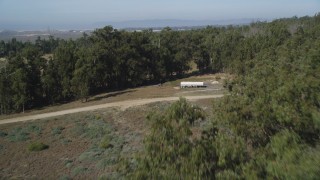 DFKSF02_014 - 5K aerial stock footage of approaching and flying over the edge of a small forest, Nipomo, California