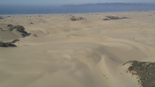 DFKSF02_019 - 5K aerial stock footage of approaching sand dunes, ATV riders, Pismo Dunes, California