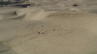 DFKSF02_020 - 5K aerial stock footage of flying by ATV riders and sand dunes, Pismo Dunes, California