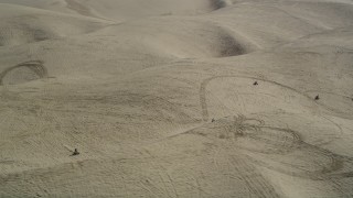 DFKSF02_021 - 5K aerial stock footage of orbiting ATV riders cruising over the sand dunes, Pismo Dunes, California