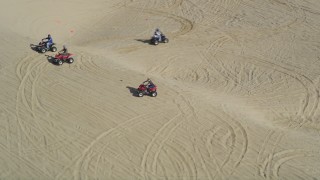 DFKSF02_029 - 5K aerial stock footage orbiting ATV riders on the sand dunes, Pismo Dunes, California