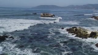 DFKSF02_041 - 5K aerial stock footage fly low over waves, rock formations, reveal coastal homes, Shell Beach, California