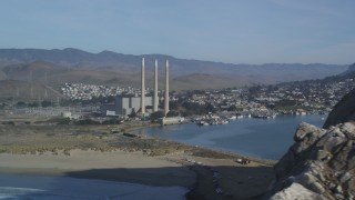 DFKSF03_003 - 5K aerial stock footage of flyby Morro Rock, reveal Dynegy Power Plant and smoke stacks, Morro Bay, California