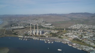 DFKSF03_007 - 5K aerial stock footage of a beach, coastal homes by the harbor, pan to reveal Dynegy Power Plant, Morro Bay, California
