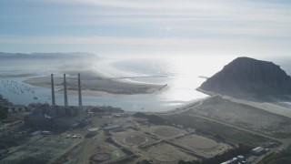 DFKSF03_011 - 5K aerial stock footage of flying by Dynegy Power Plant and smoke stacks, Morro Rock, and the coast, Morro Bay, California