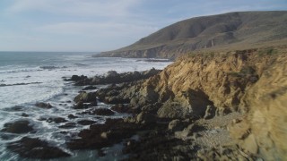 DFKSF03_025 - 5K aerial stock footage of flying over a cliff to follow the rocky coastline, Harmony, California