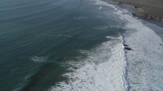 DFKSF03_052 - 5K aerial stock footage of flying over waves rolling into the coast by Highway 1, San Simeon, California