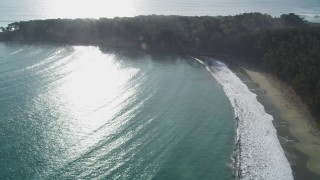DFKSF03_053 - 5K aerial stock footage of panning from a beach to trees by the ocean in San Simeon, California