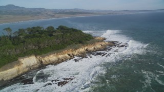 DFKSF03_055 - 5K aerial stock footage of flying by waves rolling into the coastline, San Simeon, California